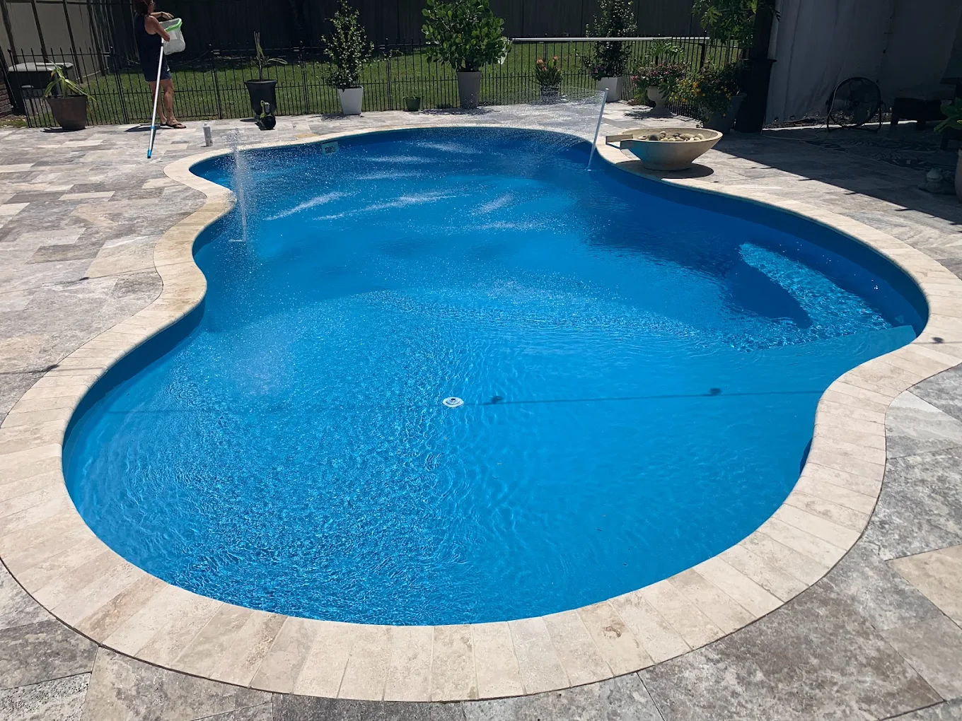 Jacksonville pool company technician cleaning an inground pool